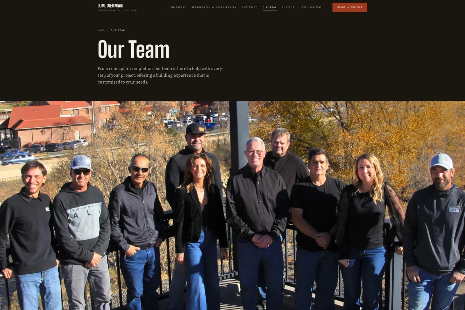 Our Team — the ten-person crew photographed at a balcony rail above town, fall cottonwoods behind.